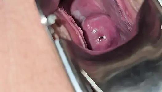 Orta yaşlı seksi kadın amını teftiş ediyor ve içine görmek için spekulum sokuyor