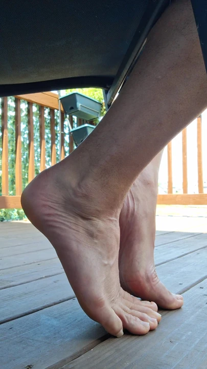 Sneak shot of my feet soles toes barefoot under a chair