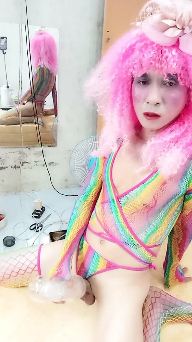 Transgender Le seksi kıyafetler giyiyor ve yapay göğüslerle seks kupaları oynuyor.