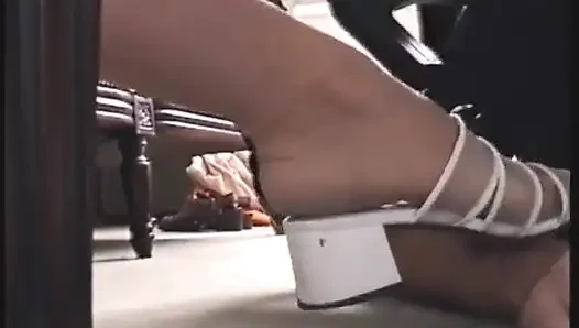 Yakın çekim videosunda köle tarafından tapılan beyaz yüksek topuklu ayakkabılar