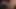 Tomina Steel, bir çift file çorap ve jartiyer kayışı içeren kırmızı iç çamaşırlı ateşli görünen uzun boylu bir esmerdir