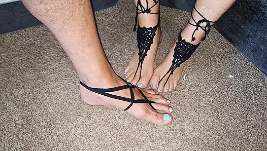 Playing footsie while wearing black strappy barefoot jewelry
