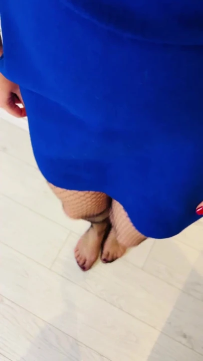 Рыжая ирландская рыжая показывает ее ноги в юбке и чулках-сеточках