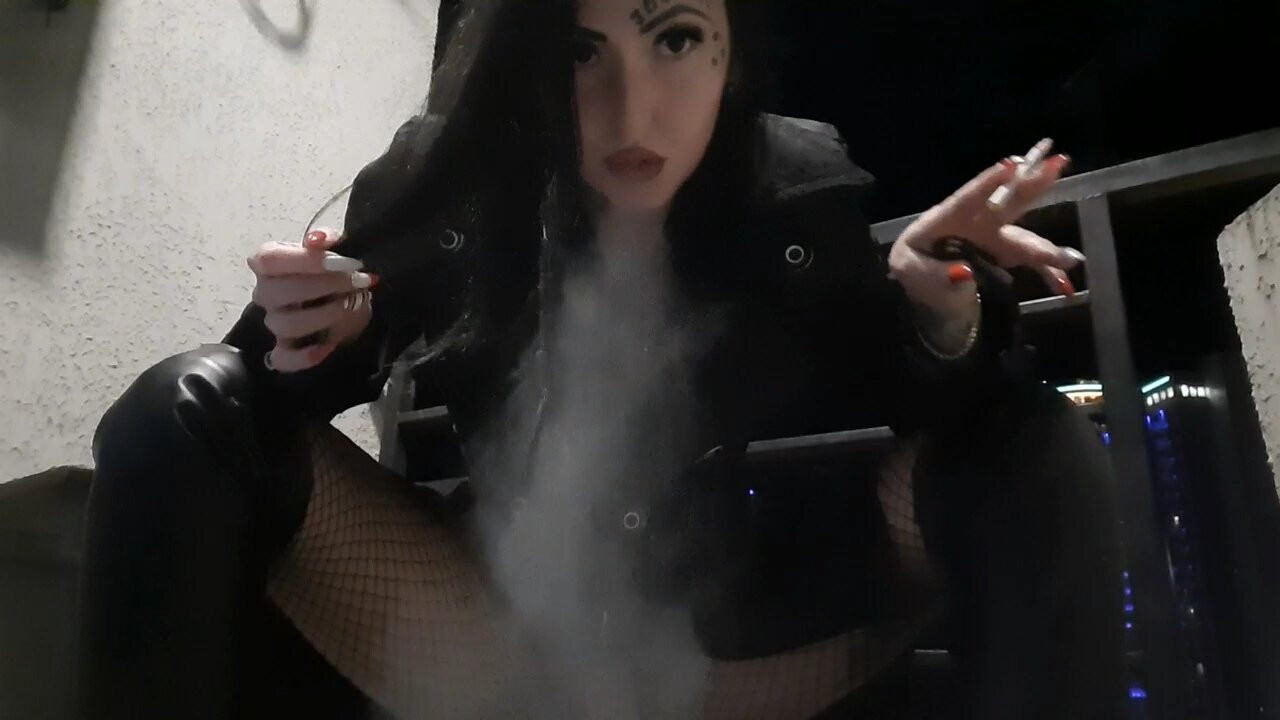 Ateşli ve seksi dominatrix nika balkonunda sigara içiyor, dumanı yüzünüze üfliyor.