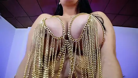 Seksi tanrıça zincir kıyafeti içinde büyük göğüsleri ile oynuyor.