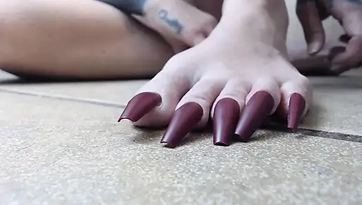 Uzun ayak tırnaklarını kırpıyor