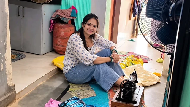 Indian wife sewing on the machine but she has other thoughts too.