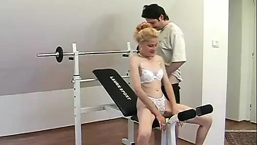 Ateşli olgun sarışın ağırlık makinesinde sert yarak ve ateşli bir yüze boşalma alıyor