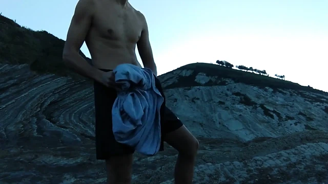 Azgın ince kahverengi adam gün batımının altında cennet gibi bir yerde sert mastürbasyon yapıyor