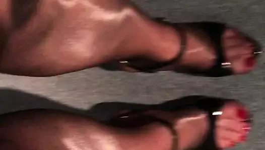 Parlak siyah kırmızı naylon çorap ve seksi topuklu kırmızı parmaklı ayaklar