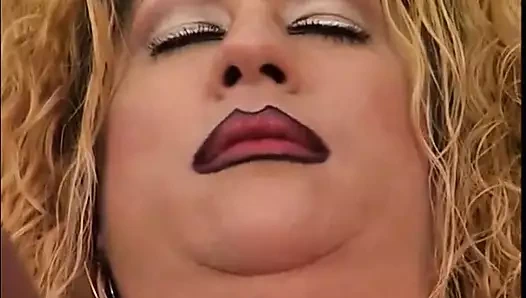 Sarışın şişman arkadaşının üzerine eğiliyor ve onu vibratörle arkadan sikiyor