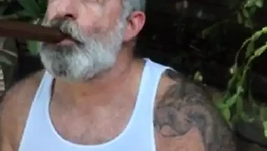 Viejo barbudo fumando puro