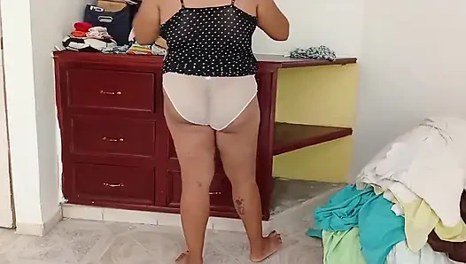 Tombul kız odayı topluyor ve kıyafetlerini katlıyor