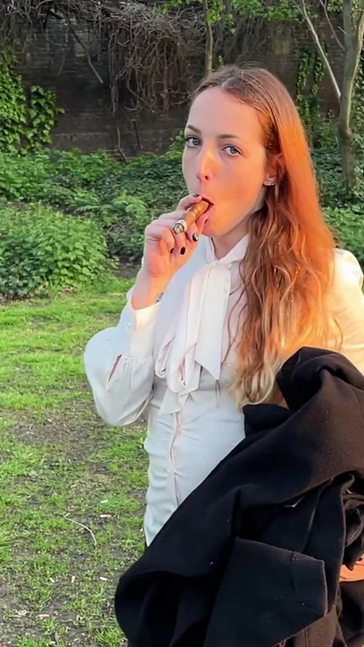 Liz Rainbow açık havada flor de oliva puro içiyor