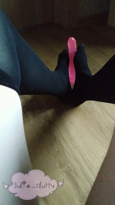 Sevimli küçük korkak siyah çorap içinde uygulama footjob çalışıyor