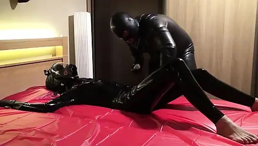 Масляное тело в латексном комбинезоне