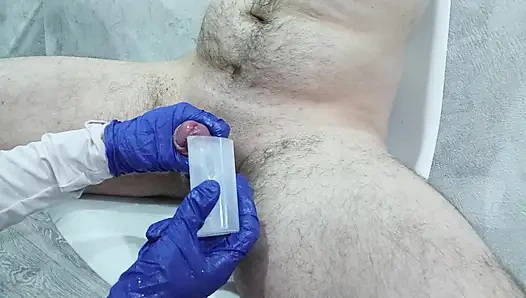 Hemşire analiz için sperm toplamak için hastanın testislerine ve penisine iyice masaj yaptı.