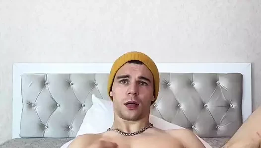 Genç, güçlü bir adam yatakta yatarken büyük bir yarağı sıvazlıyor