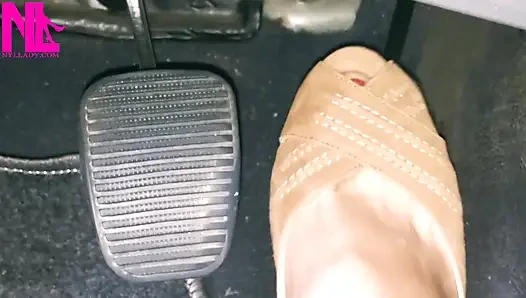 Açık kahverengi gözetleme toynağı sandaletle canlanıp araba sürüyor