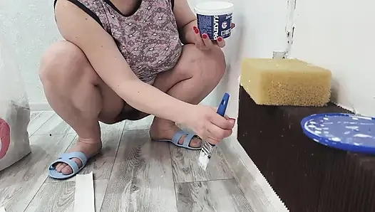 Orta yaşlı seksi kadın külotsuz bir kaloriferi boyar.