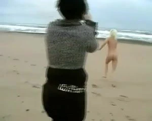 Soğuk bir kumsalda cesur sarışın çıplaklar