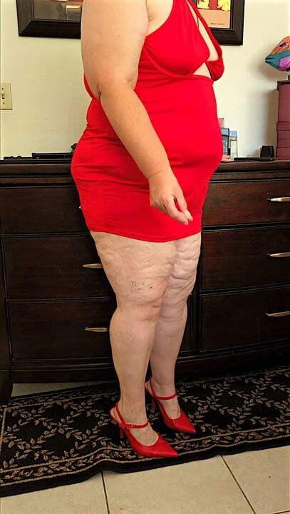 Mini kırmızı elbiseli ve yüksek topuklu güzel sosyal medya modeli gösteriş yapıyor