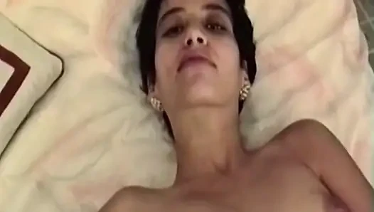 Esmer kadın yatakta soyunuyor ve soyunuyor