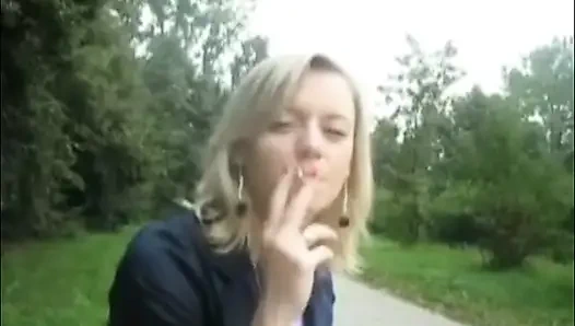 Sarışın güzel kadın açık havada sigara içiyor