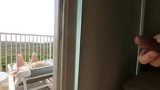 Balkonda, yanından yürüyen herkesin göz önünde güneşlenme