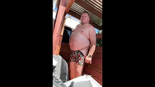 Mavi yakalı baba bahçede işiyor ve boşalıyor