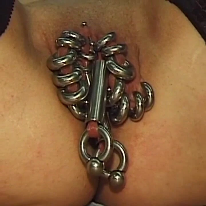 Kızıl saçlı orta yaşlı seksi kadın aşırı piercinglerini gösteriyor