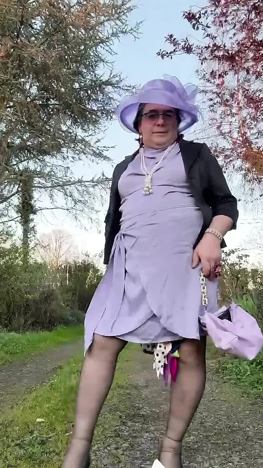 Bir akşam için leylak elbisesi ve şapkayla giyinmiş