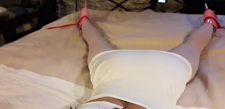 Laura одета в сексуальное белое платье, розовые колготки и каблуки на платформе, связали и заткнули рот кляпом в постели