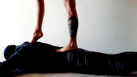 Dominatrix nika için ayak paspası. bir kölenin vücudunu çiğnemek.