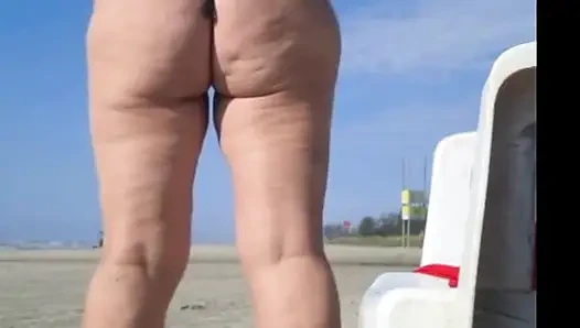 Hot crown sunbathing on the beach in transparent micro bikini