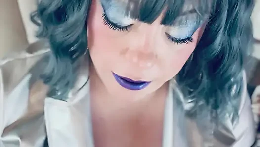 Gümüş giyinmiş ve eldivenli ve yüzüklü Tina Snua fışkırtan bir sigara içiyor