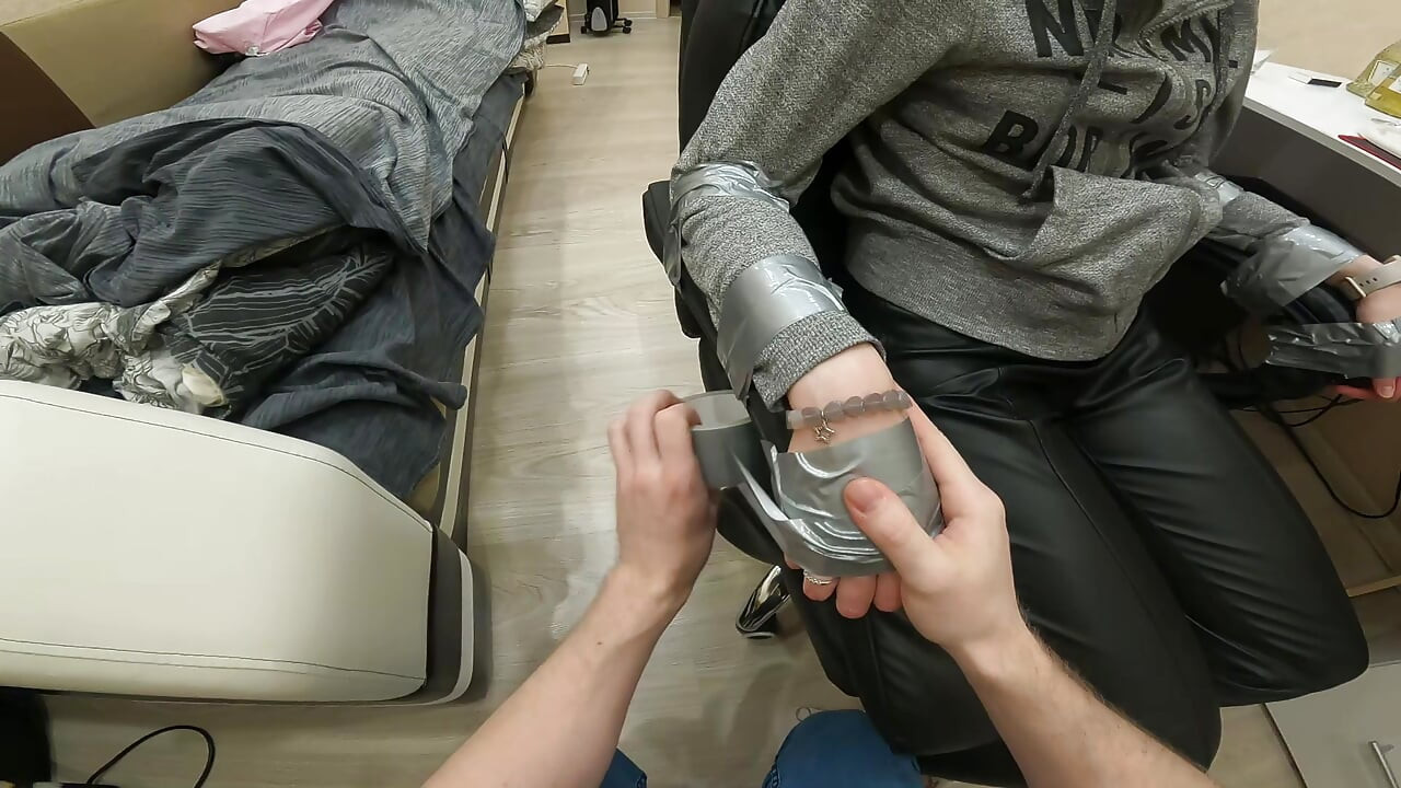 Gümüş kaset sandalyeye bağlı, deri pantolon, çorap tıkalı