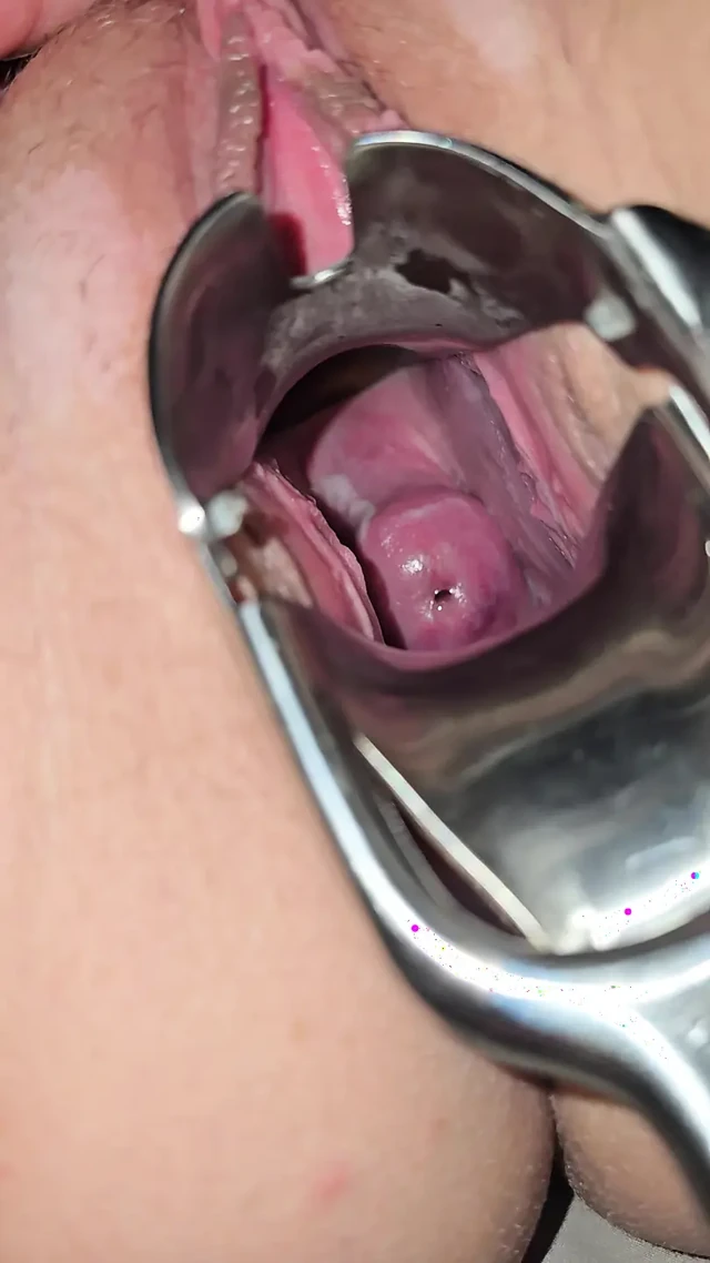 Orta yaşlı seksi kadın amını teftiş ediyor ve içine görmek için spekulum sokuyor