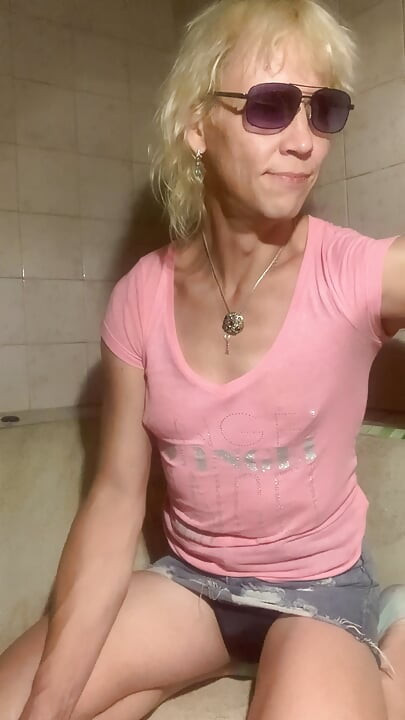 Soaking wet in bathroom in pink t-shirt, denim skirt and socks