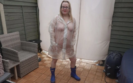 Plastik şeffaf yağmurluk altında çıplak ve wellingtons açık havada soğukta dışarı çıkıyor