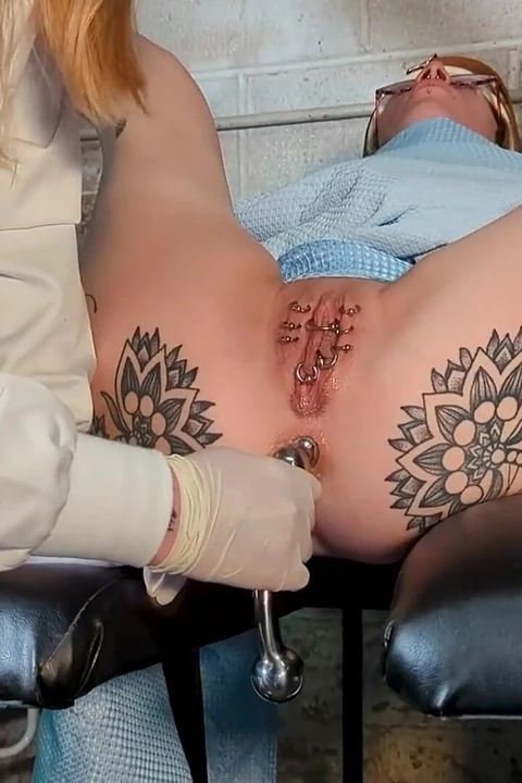 Bağlı, bağlı amcık piercingleri ve sahibe tarafından anal oyun