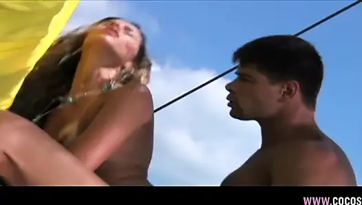 Renkli bikinili sarışın güneşli tekne güvertesinde yaramazlık yapıyor