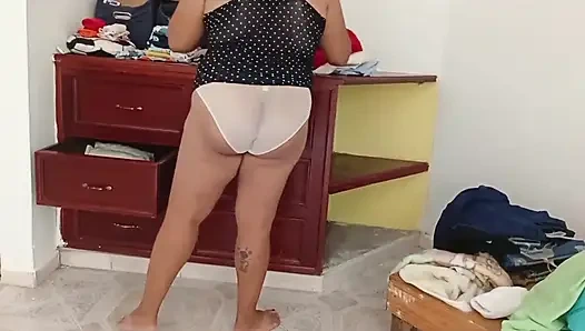 Tombul kız odayı topluyor ve kıyafetlerini katlıyor