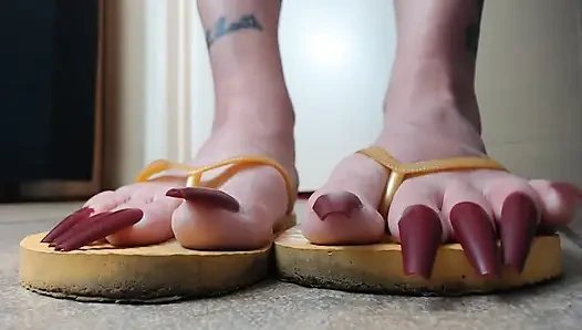 Toenails sarı parmak arası terliklerini sallıyor