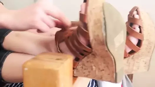 Güzel sarışın kama sandaletlerini çıkarır ve tatlı tabanlar gösterir.