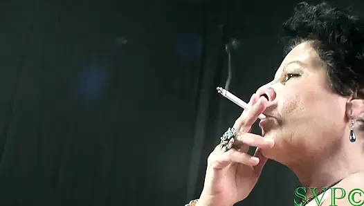 Genç erkek avcısı iri güzel kadın sigara içiyor ve pozlar atıyor