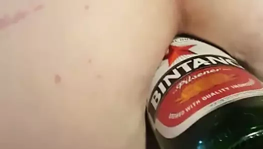 Amil üzerinde, kıçına büyük bir bira şişesi alır