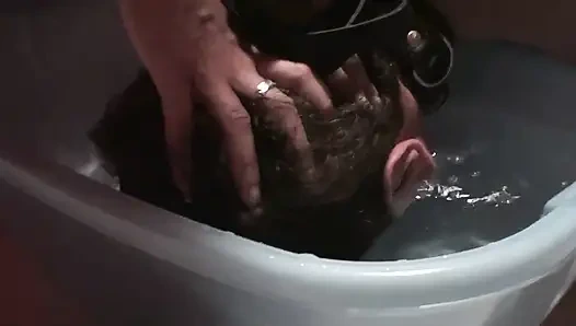 Kölenin kafasını suya sokuyor