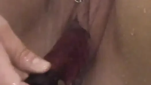 Amcığı pirsingli tam figürlü sarışın yapay penisle kendini sikmek için duşta oturuyor