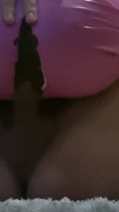 Pembe lateks pantolona biniyor